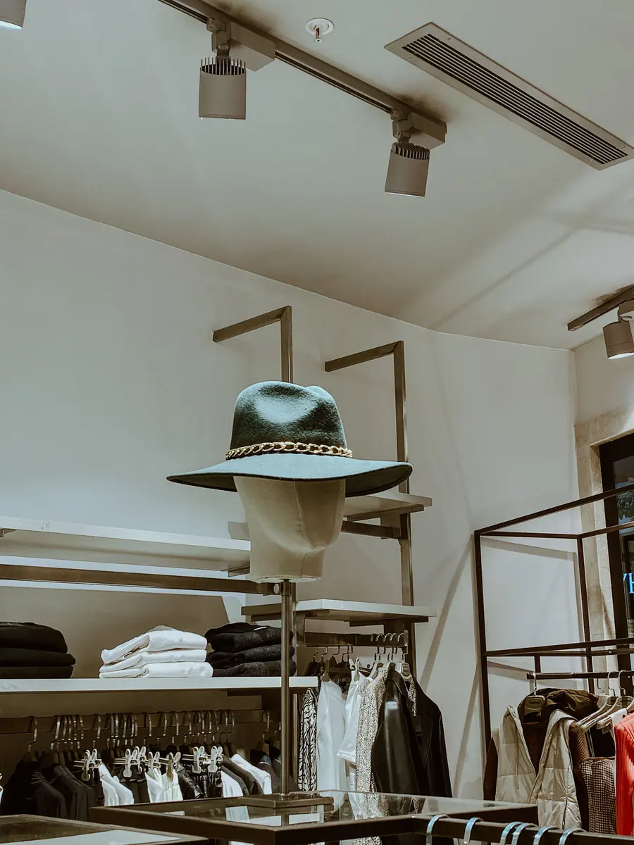 Boutique interior with a hat on a mannequin head and clothing racks