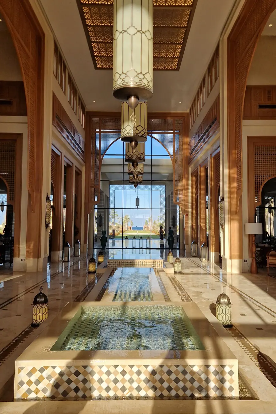 Grand hotel lobby with a hanging lantern and ornate arches